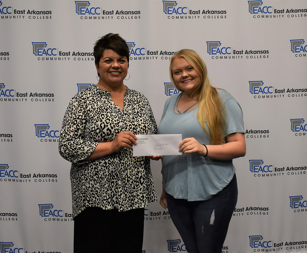 Niki Jones, EACC Director of Development, presents scholarship to Dakota Bridges